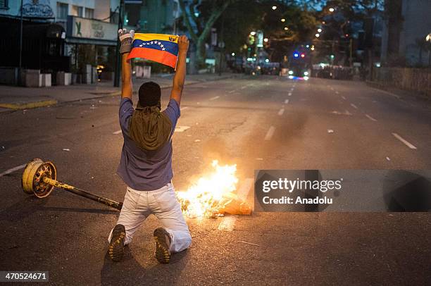 An anti-government protester holds up a national flag during a demonstration in the Altamira neighborhood of Caracas, Venezuela, on February 19, 2014.