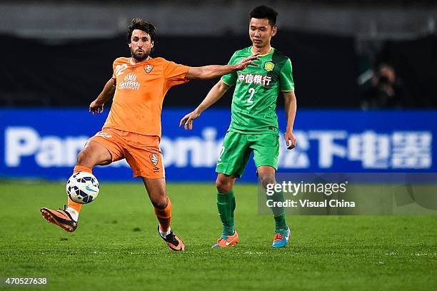 Thoas Broich of Brisbane Roar competes for the ball with Li Yunqiu of Beijing Guoan during the Asian Champions League match between Beijing Guoan and...