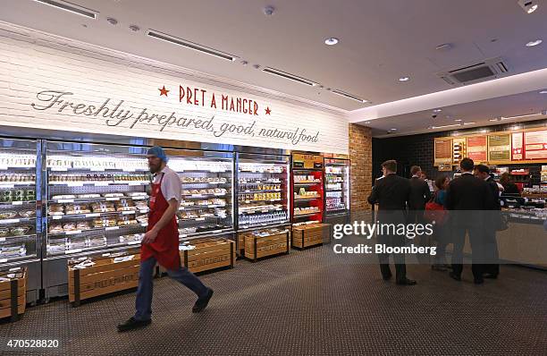 An employee walks past a chilled display of sandwiches and salads inside a Pret A Manger sandwich store, operated by private equity firm Bridgepoint,...