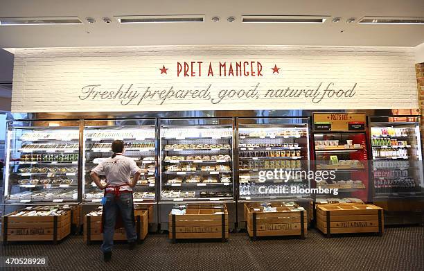 An employee checks the stock levels of a chilled display of sandwiches and salads inside a Pret A Manger sandwich store, operated by private equity...