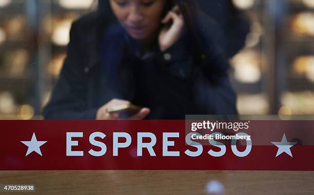 Customer uses her mobile phone as she sits inside a Pret A Manger sandwich store, operated by private equity firm Bridgepoint, in London, U.K., on...