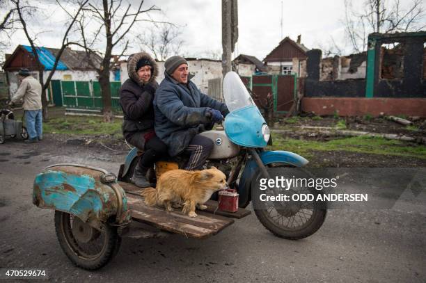 Couple and their dog ride a motorbike with a side-car in the village of Nikishino on April 21, 2015 in the self-proclaimed Donetsk People's Republic...