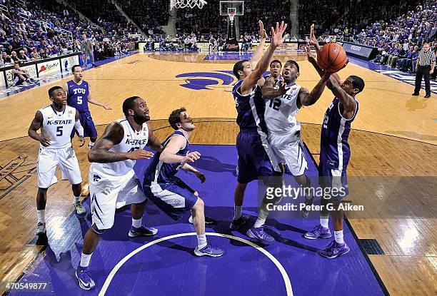 Guard Omari Lawrence of the Kansas State Wildcats drives to the basket between defenders Amric Fields and Jarvis Ray of the TCU Horned Frogs during...