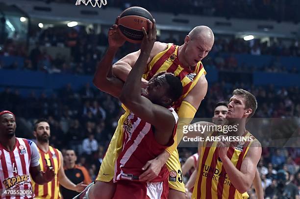 Barcelona's center Maciej Lampe blocks a field goal attempt by Olympiakos' center Bryant Dunston during their round three play-off Euroleague...