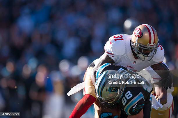 Donte Whitner of the San Francisco 49ers attempts to tackle Greg Olsen of the Carolina Panthers during the NFC Divisional Playoff Game between the...
