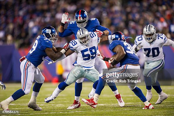 Ernie Sims of the Dallas Cowboys defends his position against runner Andre Brown of the New York Giants during the game between the two teams at...