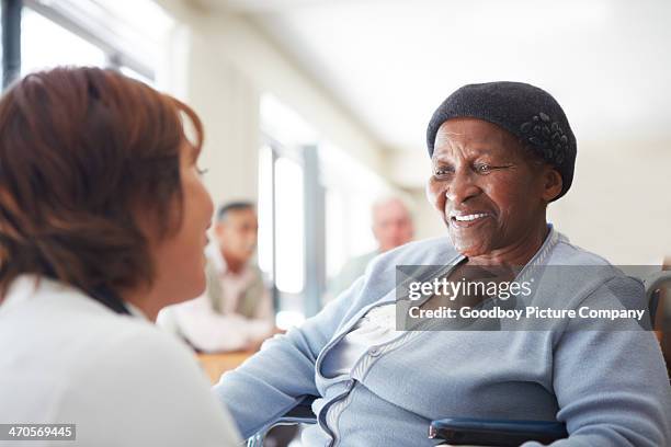 enjoying her caregiver's attentive care - doctor looking over shoulder stock pictures, royalty-free photos & images