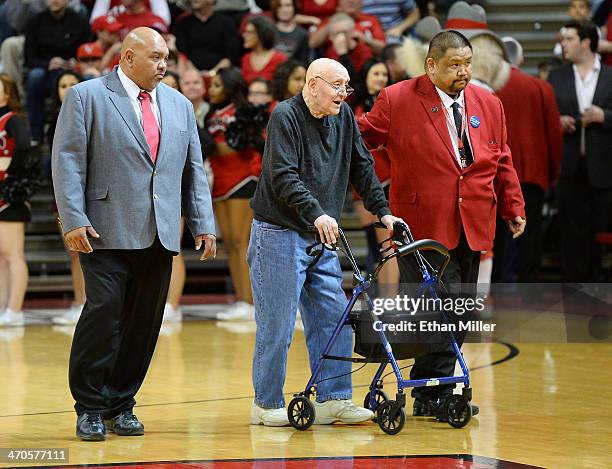 Former UNLV head basketball coach Jerry Tarkanian is escorted to his courtside seat by head security supervisor Eli Cordeiro and usher Ronnie Luneza...