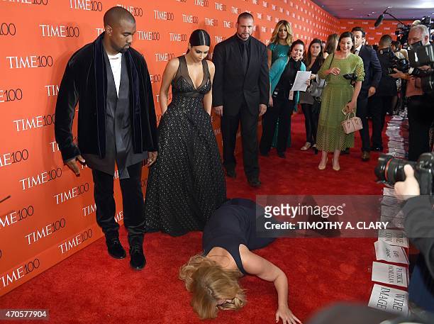 Honoree and Comedian Amy Schumer pretends to trip and fall on the floor in front of honorees Kim Kardashian and Kanye West as they attend the Time...