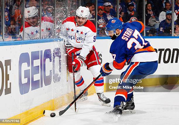 Marcus Johansson of the Washington Capitals battles for the puck with Brian Strait of the New York Islanders during Game Four of the Eastern...