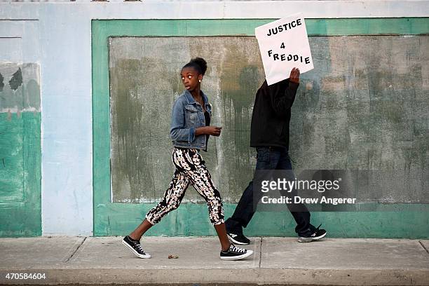 Protestors walk toward Baltimore Police Department's Western District police station during a march and vigil over the death of Freddie Gray, April...