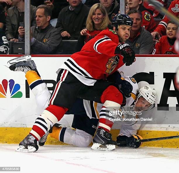 Brent Seabrook of the Chicago Blackhawks dumps Gabriel Bourque of the Nashville Predators into the boards in Game Four of the Western Conference...