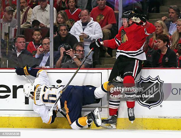 Bryan Bickell of the Chicago Blackhawks dumps Mike Ribeiro of the Nashville Predators in Game Four of the Western Conference Quarterfinals during the...