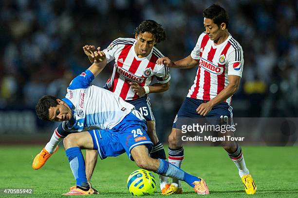 Sergio Perez of Puebla fights for the ball with Fernando Arce and Jose Toledo of Chivas during a Championship match between Puebla and Chivas as part...