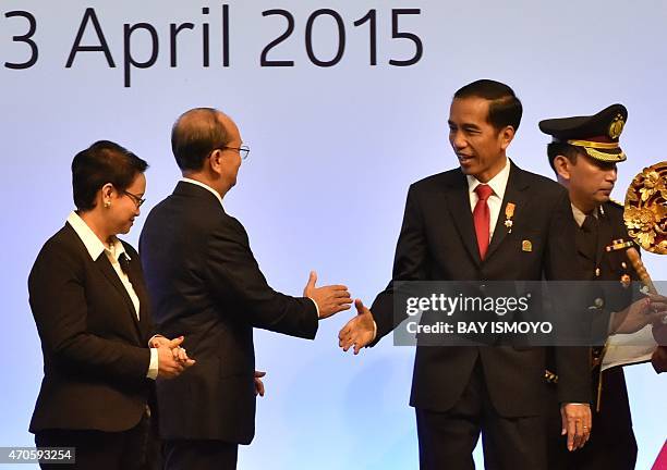 Indonesia's President Joko Widodo shakes hands with Myanmar President Thein Sein as Indonesian Foreign Minister Retno Lestari Marsudi looks on during...