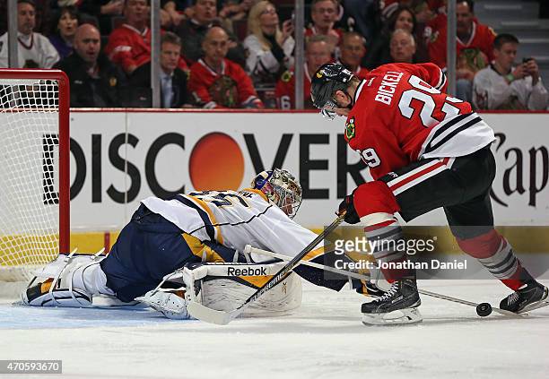 Pekka Rinne of the Nashville Predators knocks the puck away from Bryan Bickell of the Chicago Blackhawks in Game Four of the Western Conference...