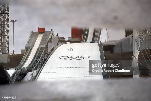 Competitor is reflected in a puddle during the Nordic Combined Team Large Hill on day 13 of the Sochi 2014 Winter Olympics at RusSki Gorki Jumping...