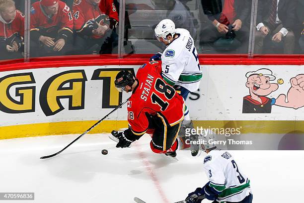 Matt Stajan of the Calgary Flames skates against Luca Sbisa of the Vancouver Canucks at Scotiabank Saddledome for Game Four of the Western...