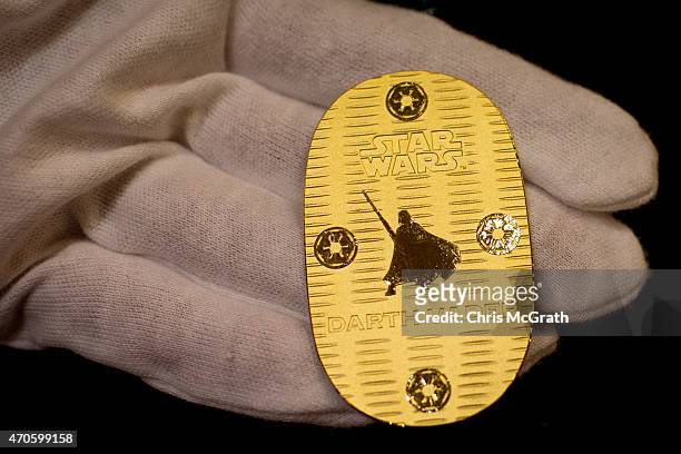 An employee displays a Darth Vader coin at Ginza Tanaka jeweler on April 22, 2015 in Tokyo, Japan. To celebrate the release of the new Star Wars film...
