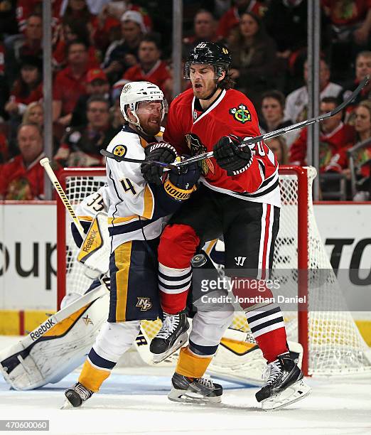 Brandon Saad of the Chicago Blackhawks collides with Ryan Ellis of the Nashville Predators as the puck hits him in the leg in Game Four of the...