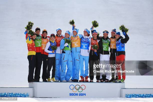 Silver medalists Germany, gold medalists Norway and bronze medalists Austria celebrate during the flower ceremony for the Nordic Combined Men's Team...