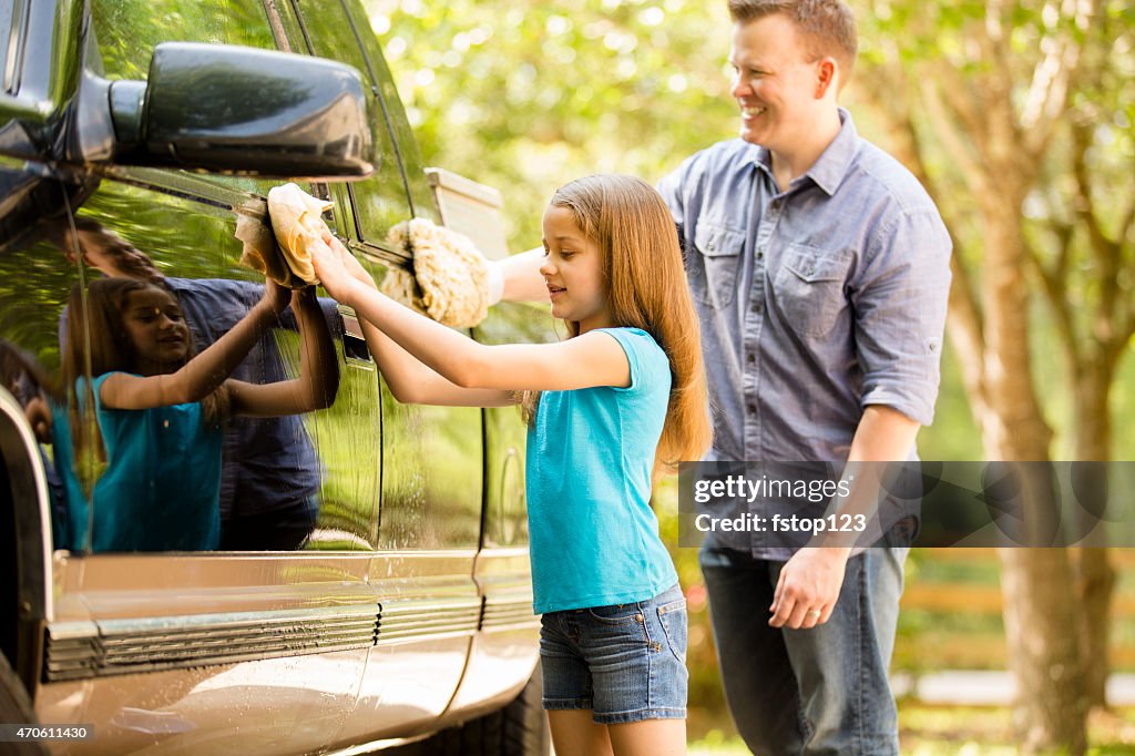 Father and daughter wash the family vehicle together outdoors.