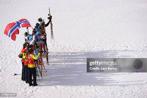 Silver medalists Germany, gold medalists Norway and bronze medalists Austria celebrate during the flower ceremony for the Nordic Combined Men's Team...