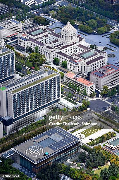 In this aerial image, investigators check a drone, under tarpaulin, on the roof of the prime minister's official residence while the diet building is...