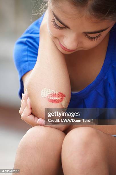 caucasian girl with lipstick kiss over bandage on elbow - lippenstiftabdruck stock-fotos und bilder