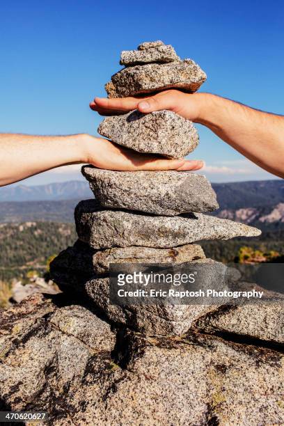caucasian couple stacking their hands in rocks - symbiotic relationship stock pictures, royalty-free photos & images