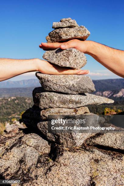 caucasian couple stacking their hands in rocks - symbiotic relationship 個照片及圖片檔