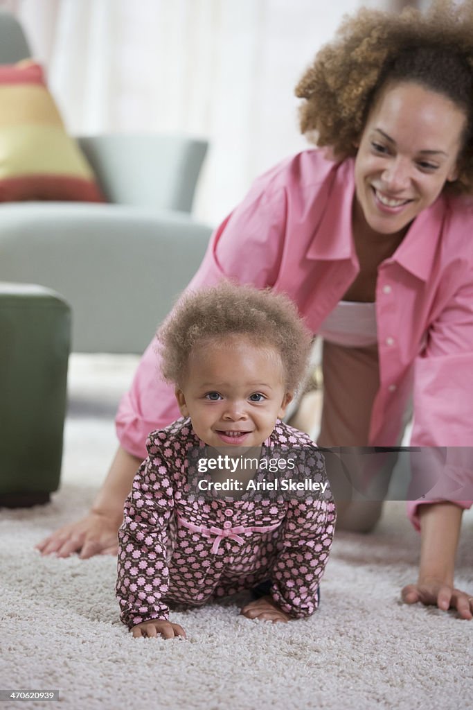 Black mother crawling with baby