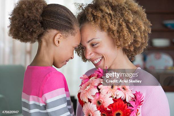 black mother and daughter holding bouquet of flowers - kids birthday present stock pictures, royalty-free photos & images