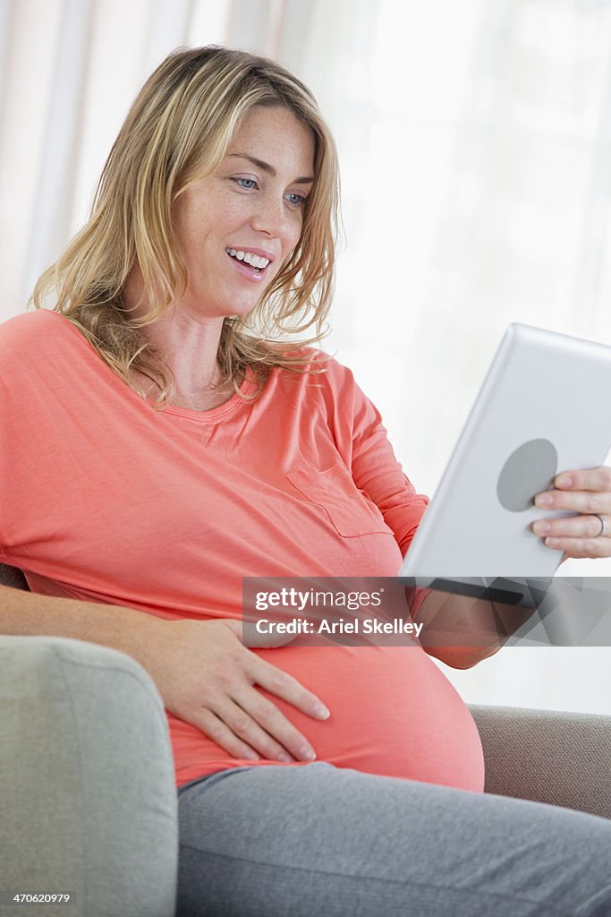 Pregnant Caucasian woman using digital tablet