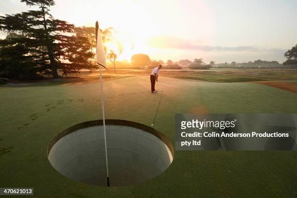 caucasian man playing golf on course - club de golf photos et images de collection
