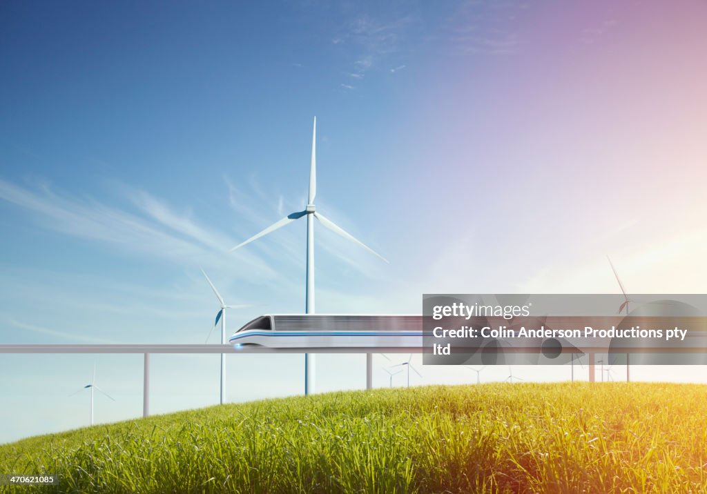 Monorail and wind turbines in grassy field