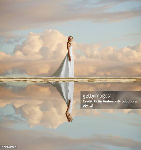 caucasian bride reflected in still lake - women in see through dresses stock-fotos und bilder