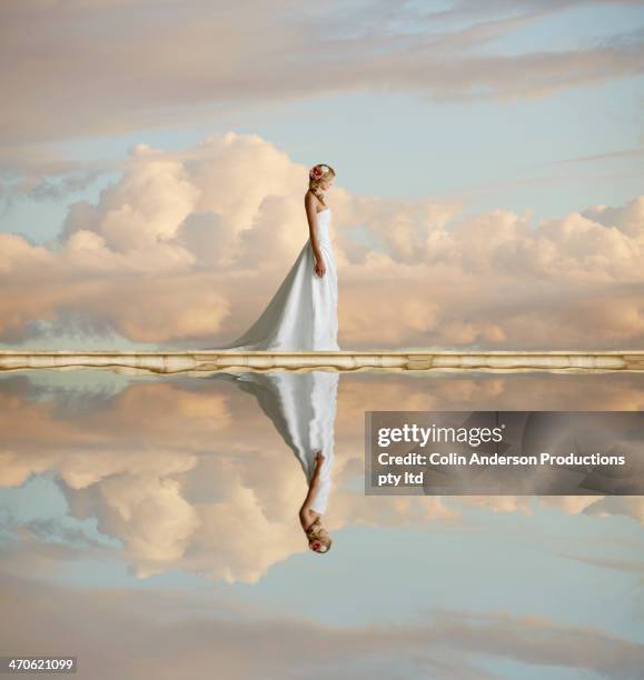 caucasian bride reflected in still lake - bride dress photos et images de collection