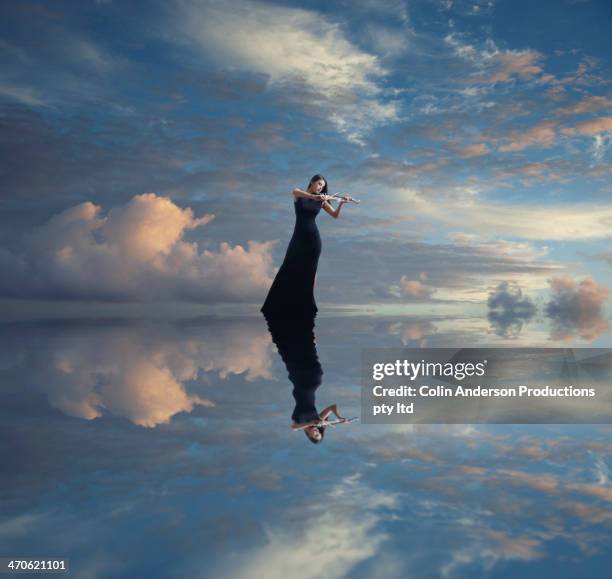 caucasian woman with violin reflected in still lake - violinist foto e immagini stock