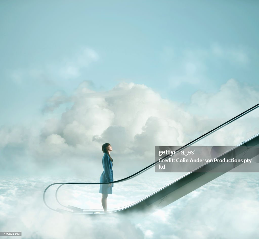 Pacific Islander woman riding escalator in sky