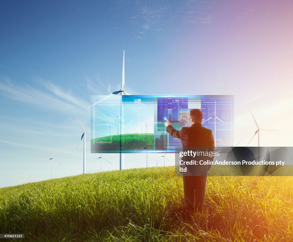 Mixed race businessman using touch screen computer outdoors