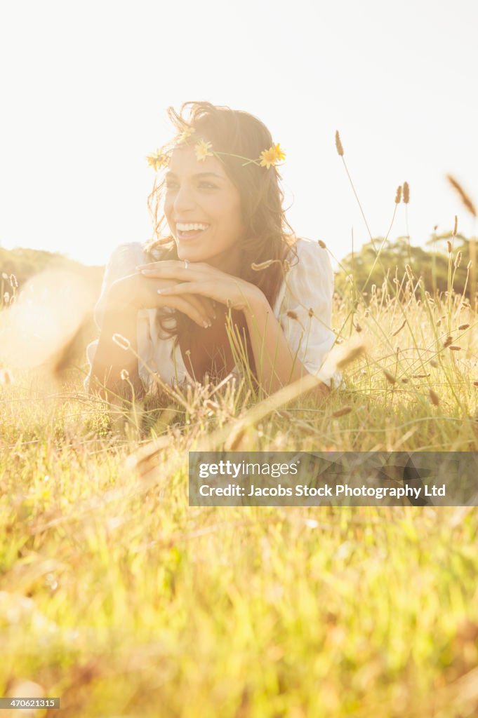 Hispanic woman wearing flower crown in grass