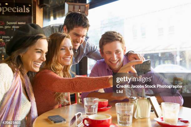 friends taking self-portrait in cafe - four people foto e immagini stock