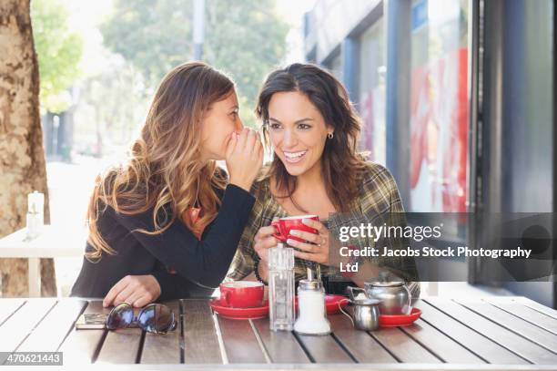 mixed race women having tea at sidewalk cafe - secret stock pictures, royalty-free photos & images