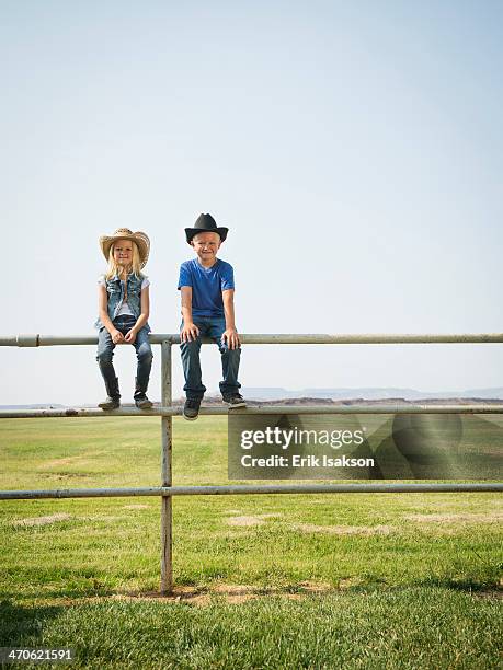 caucasian children sitting on fence on farm - st george utah 個照片及圖片檔