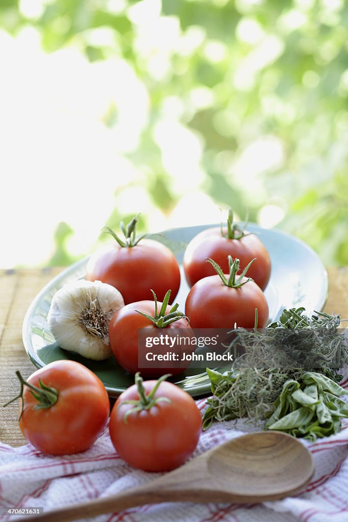 Tomatoes, garlic and herbs on table