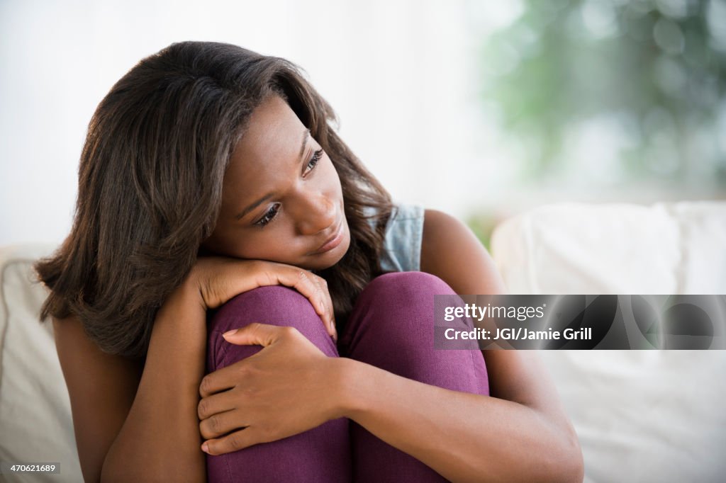 Black woman hugging her knees