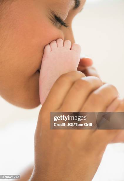 hispanic mother kissing baby's feet - baby head in hands stock pictures, royalty-free photos & images