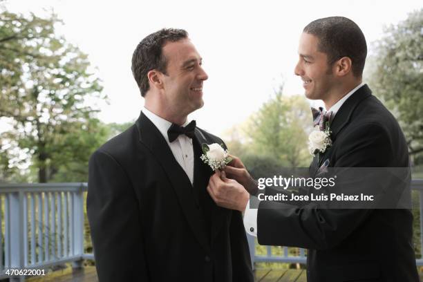 best man tying groom's boutonniere - best man stock pictures, royalty-free photos & images