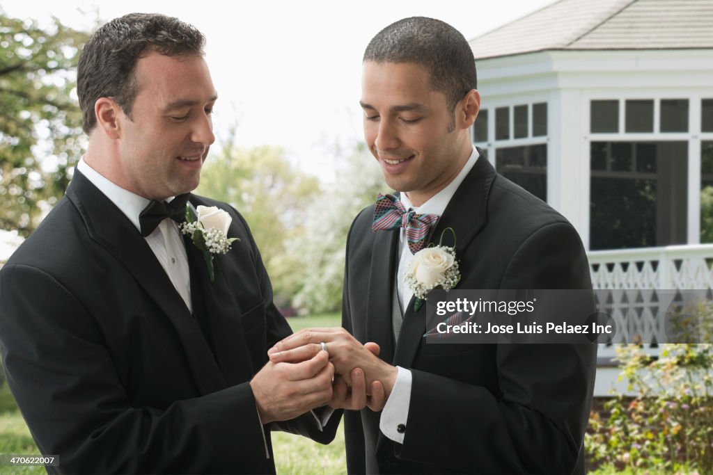 Groom placing ring on husband's finger